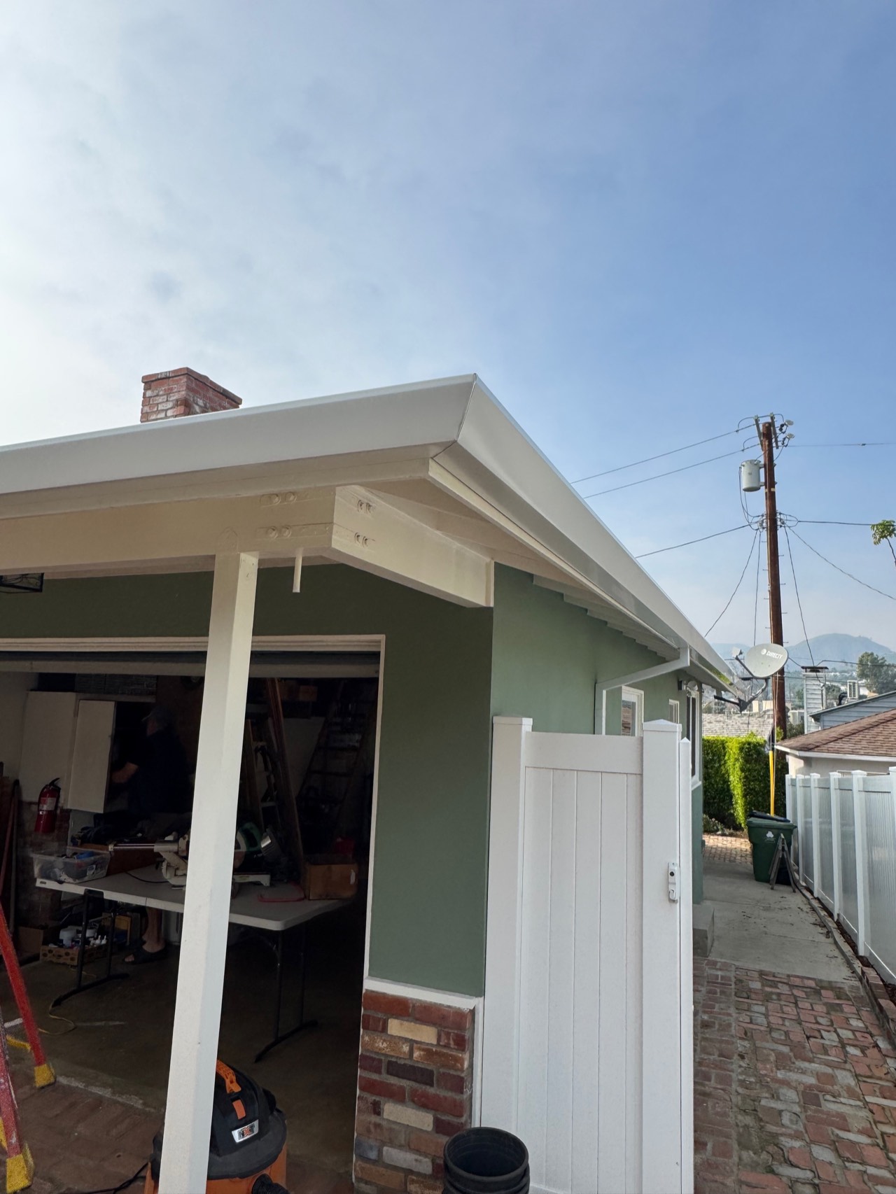 White fascia gutter along the roof edge of a green house in the Los Angeles area